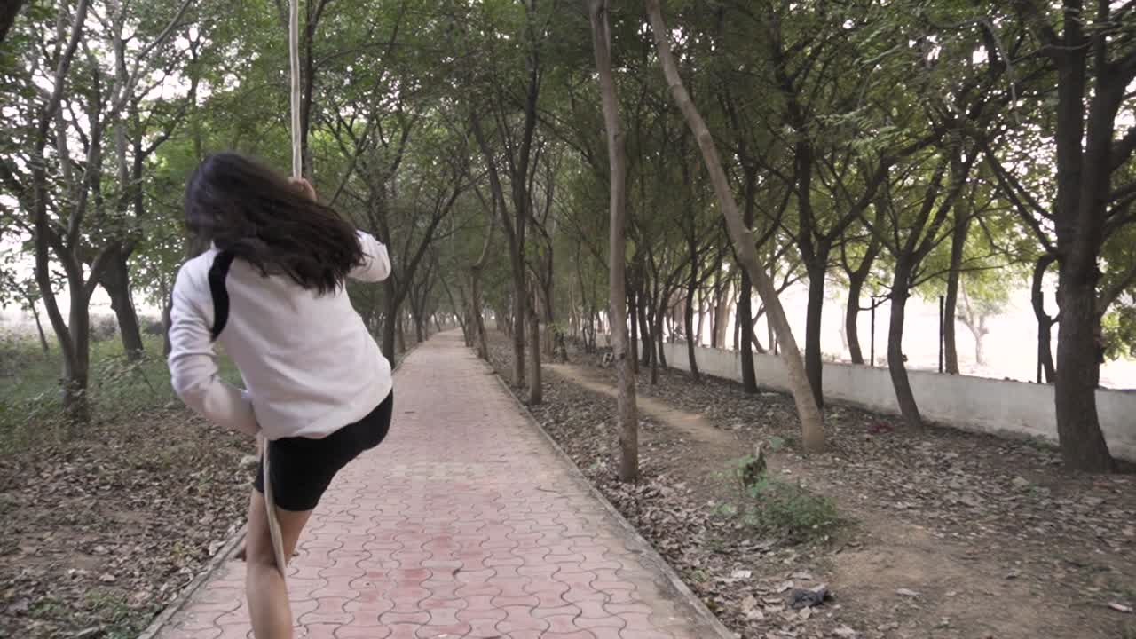 스포티한 체조 선수가 운동복을 입고 로프로 운동을 한다