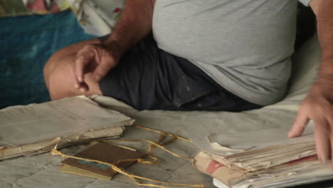 old hands sift through faded documents, stories lived and written in coastal exile at the darien gap - colombia