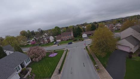 aerial fpv over housing area with homes and buildings during cloudy day in spring