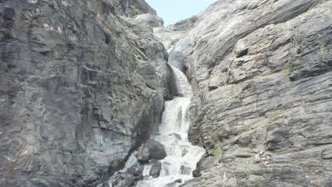 antena cinematográfica de una pequeña cascada que baja de una gran montaña