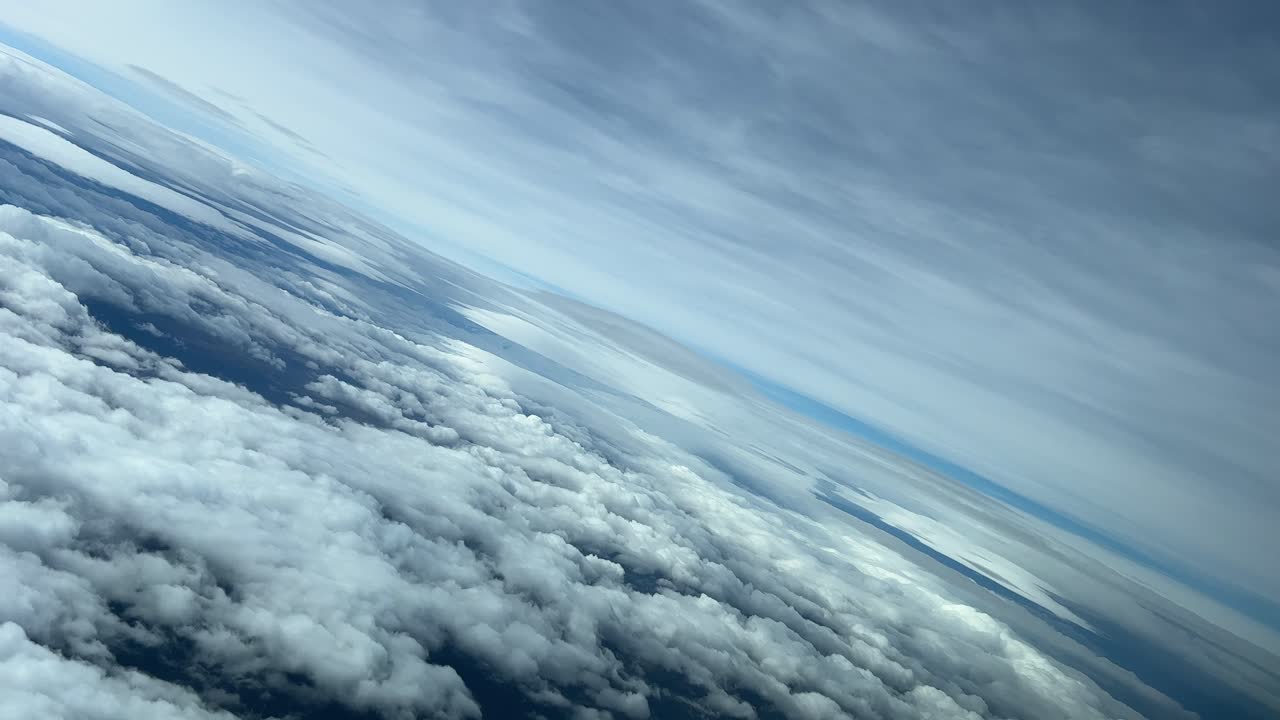 Virata a sinistra attraverso cieli nuvolosi: una vista mozzafiato dalla cabina di pilotaggio di un jet che vola a 10000 m di altezza