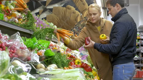 man and woman buying fresh vegetables in supermarket