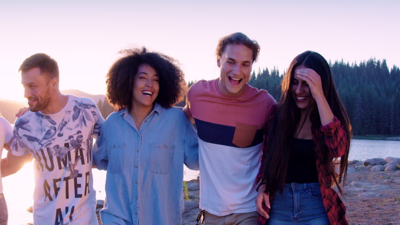 Friends Enjoying Sunset By The Lake