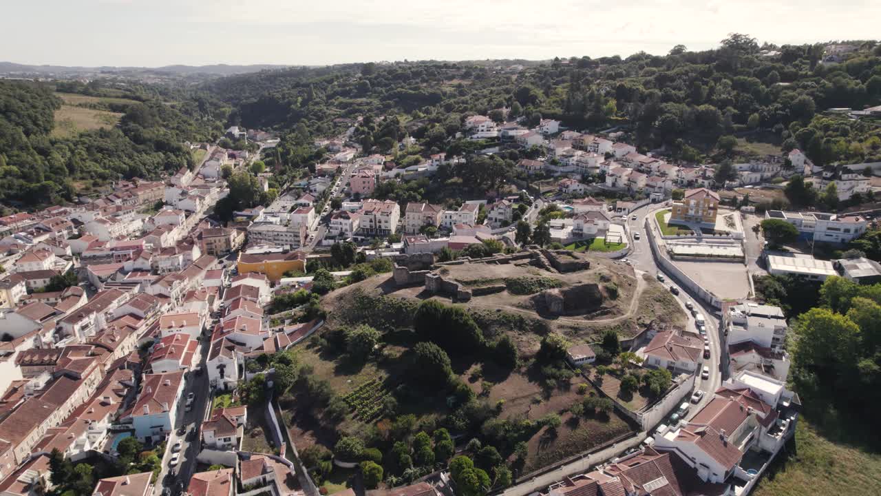 toma en órbita que captura las ruinas de castelo de alcobaça y el paisaje urbano de la parroquia en portugal