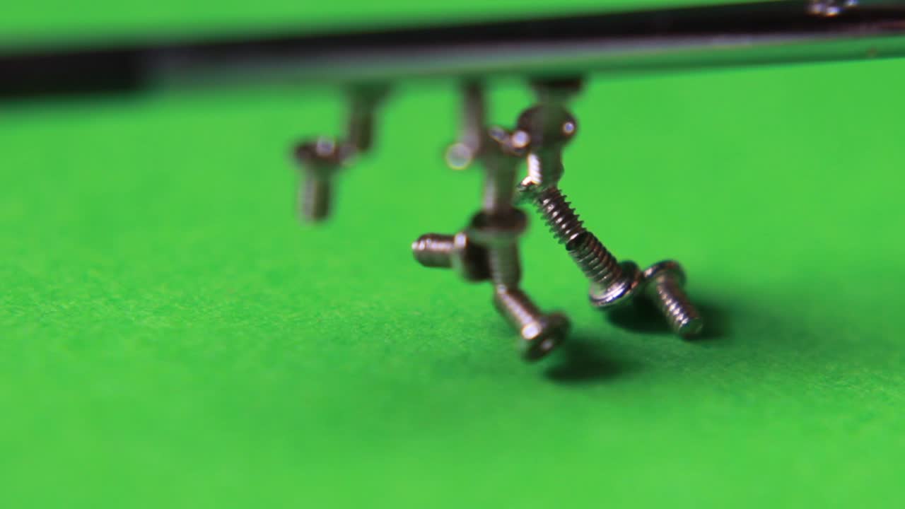 The magnetized screwdriver gathers all small screws from the green background