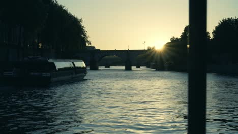 Sonnenuntergang-In-Paris-Am-Fluss-Siena,-Während-Ein-Boot-Vorbeifährt