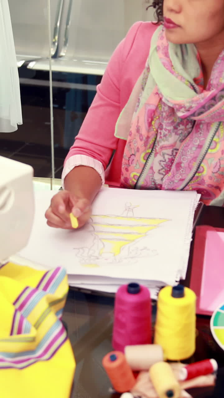 Attractive female fashion designer drawing at work