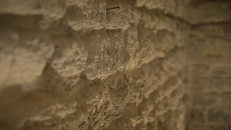 pared de piedra en un alcantarillado romano con luz amarilla tenue, tiro cercano