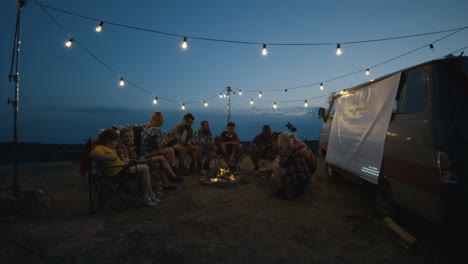 friends camping and enjoying the night by campfire