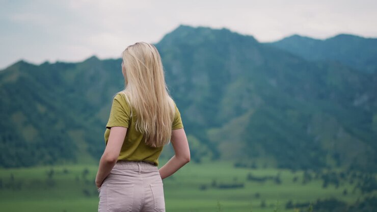 радостная леди-путешественница наслаждается связью с природой в высокогорье