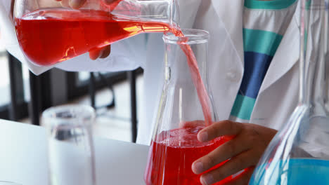 escolar atento haciendo un experimento químico en el laboratorio