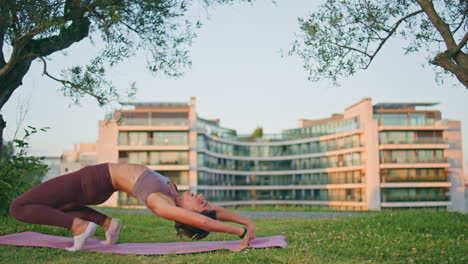 mujer flexible realizando la postura del puente en el parque soleado. mujer delgada practicando yoga