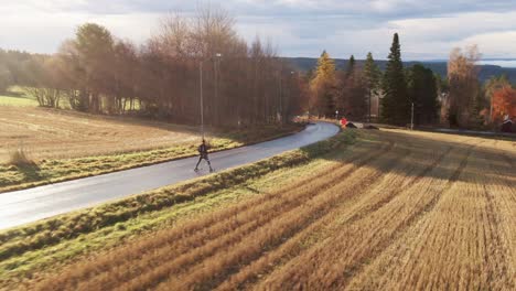 man skiing down the street near lake town ostersund, sweden during sunset