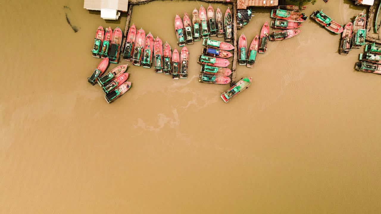 항구에 있는 동남아시아의 다채로운 트롤선이 낚시하러 부두를 떠납니다.