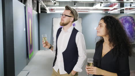 couple enjoying champagne in an art gallery