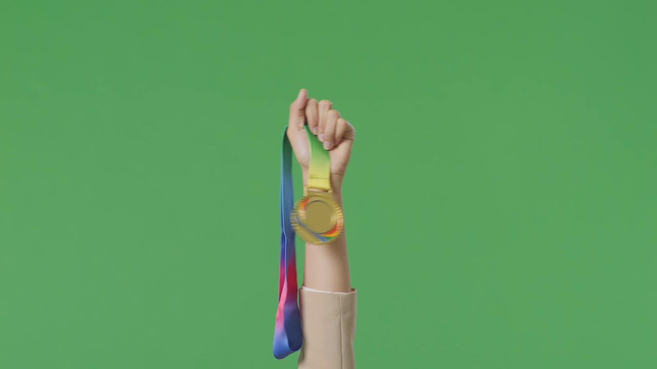 cerca de la mano de la mujer de negocios sosteniendo una medalla de oro en el aire para celebrar la victoria como el primer ganador en el fondo de la pantalla verde en el estudio