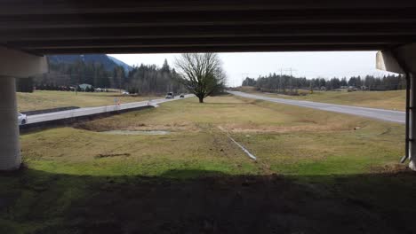 Get-a-mesmerizing-view-as-we-zoom-out-from-beneath-a-Highway-1-bridge,-capturing-traffic-in-both-directions