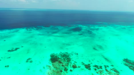 Textura-Oceánica-Con-Colores-De-Agua-Azul-Profundo-Y-Turquesa,-Patrones-Naturales-Abstractos-De-Arrecife-De-Coral-En-Fondo-De-Arena-Blanca-Bajo-Agua-Clara-En-El-Caribe