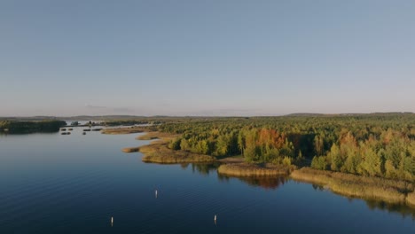 the drone shot shows a lake and its shoreline as the drone moves forward