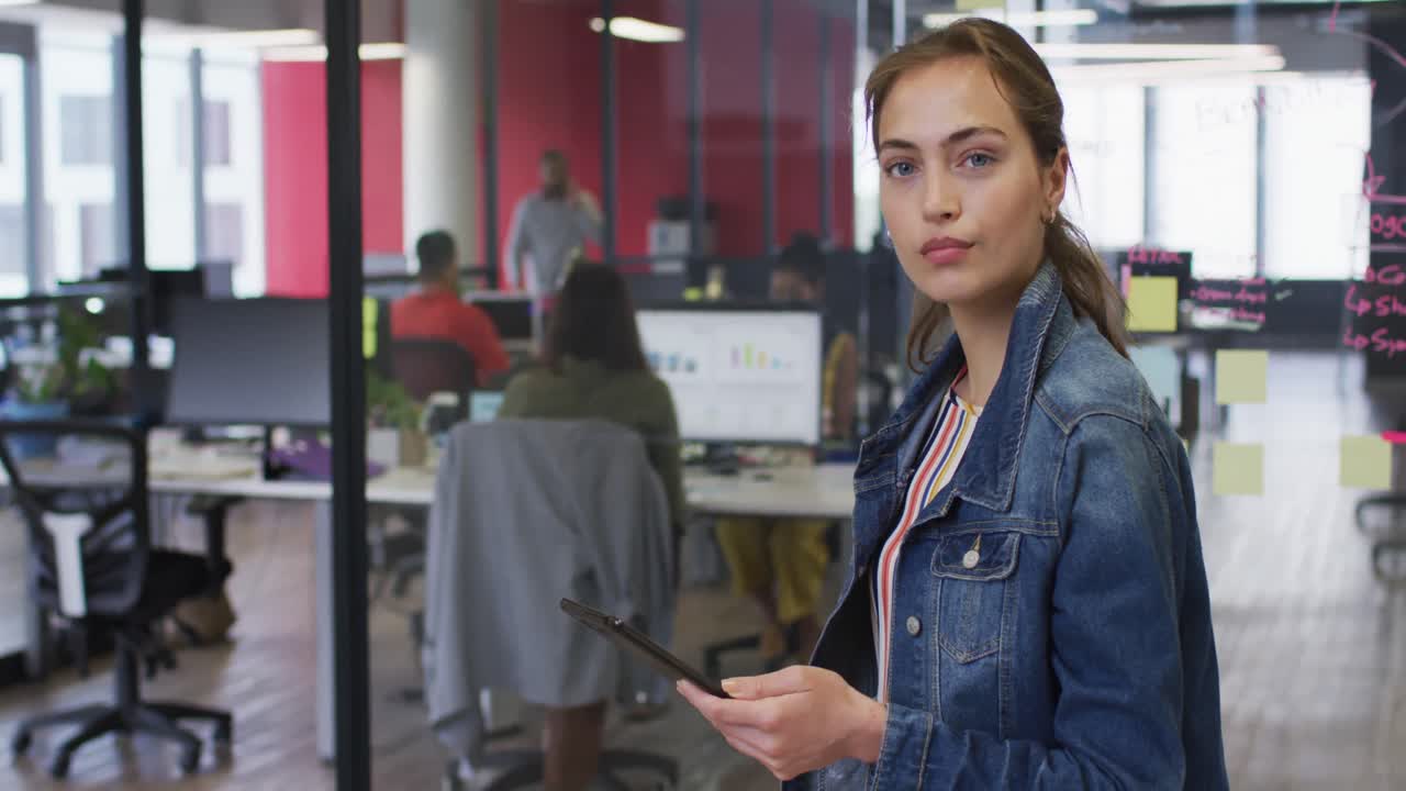 mujer de negocios caucásica con una tableta sonriendo a la cámara