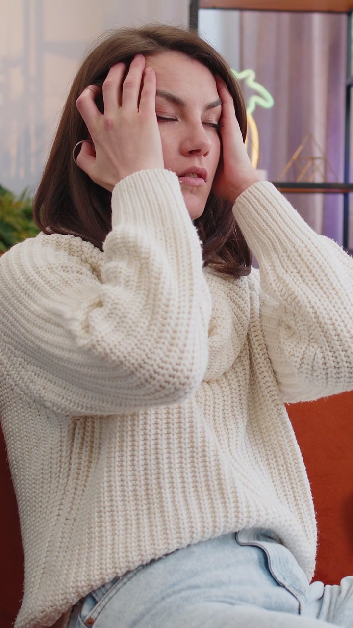 Displeased young woman rubbing temples to cure headache problem suffering from migraine stress