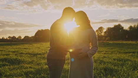 pregnant couple at sunset