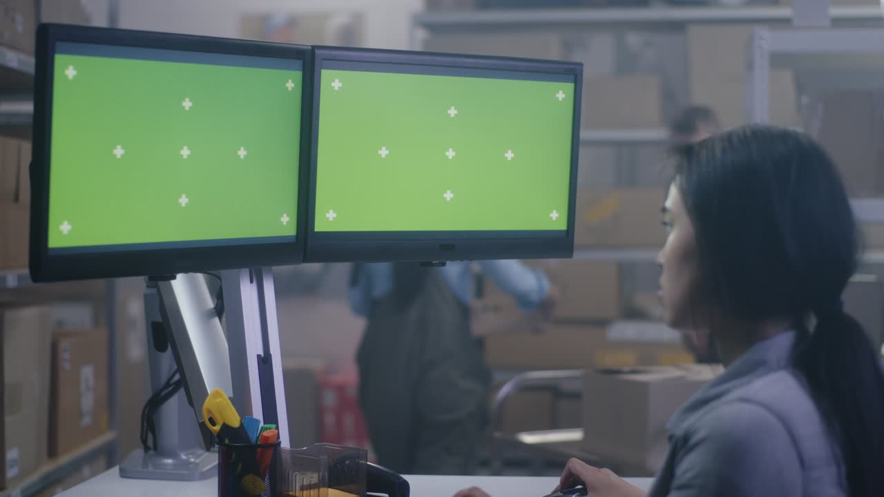 mujer joven trabajando en una computadora en un centro de distribución