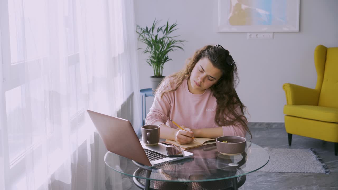 Pretty woman has breakfast on workplace at home