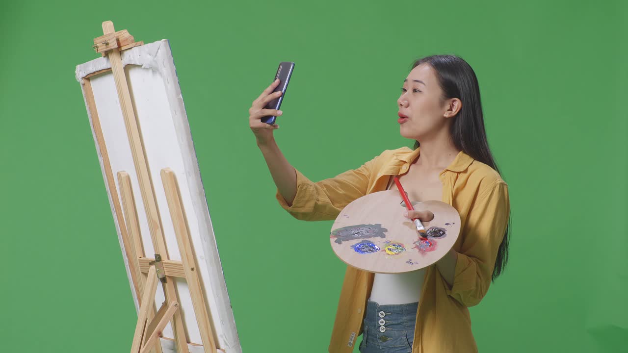 그림을 그리는 동안 셀피를 찍는 여자