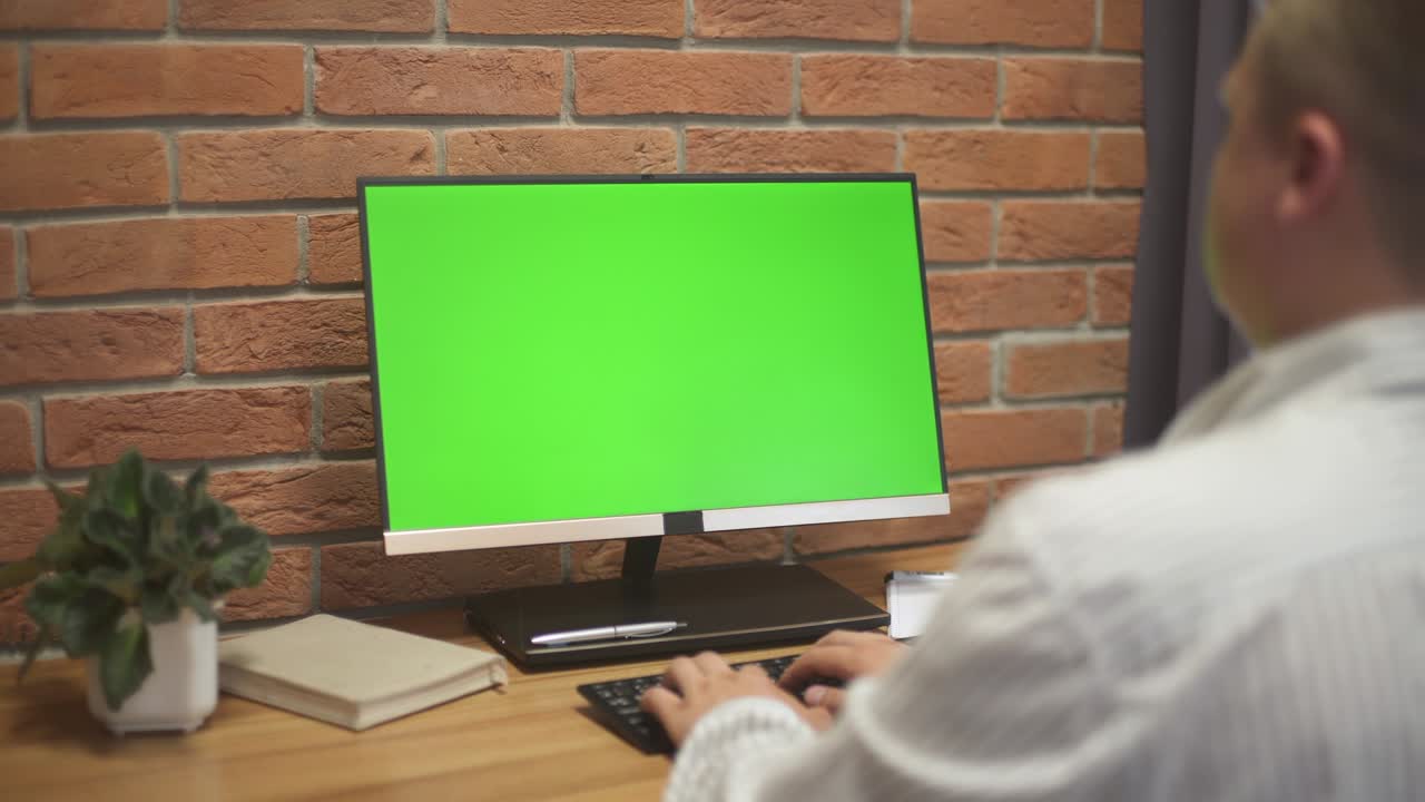 joven trabajando en una computadora con pantalla verde en la oficina. 4k