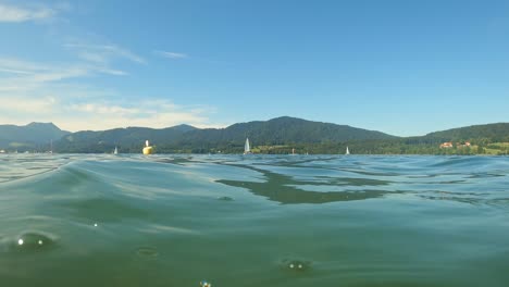 Right-at-the-water-sea-level---wonderful-summer-view-over-the-waves-of-a-lake-with-mountains-in-the-background