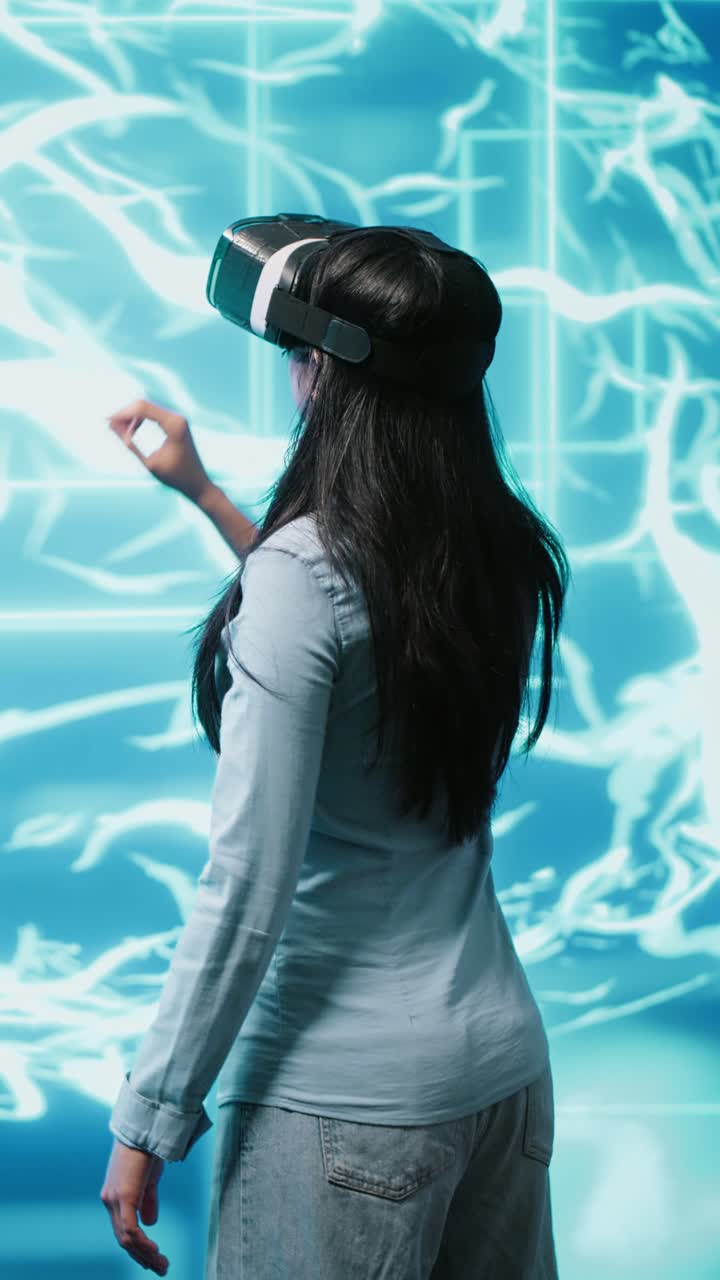 Vertical video Developer wearing VR headset looking at artificial intelligence hologram