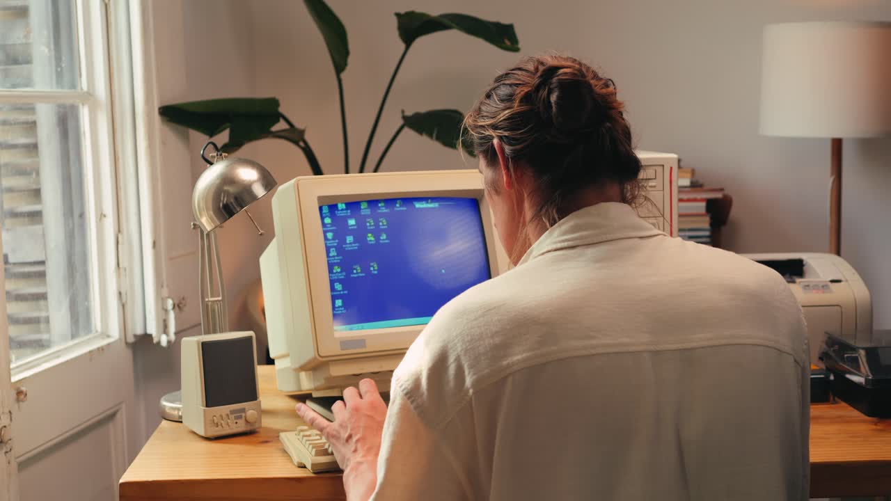 Man working and gaming on retro computer PC, IT engineer with vintage computer at home, using old fashion technology, close up of retro setup.