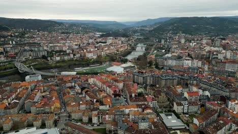 aerial establishing shot of ourense bridges crossing river in middle of town