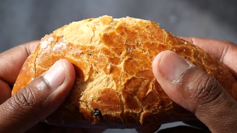 close up of a soft, golden brown bread being broken in half