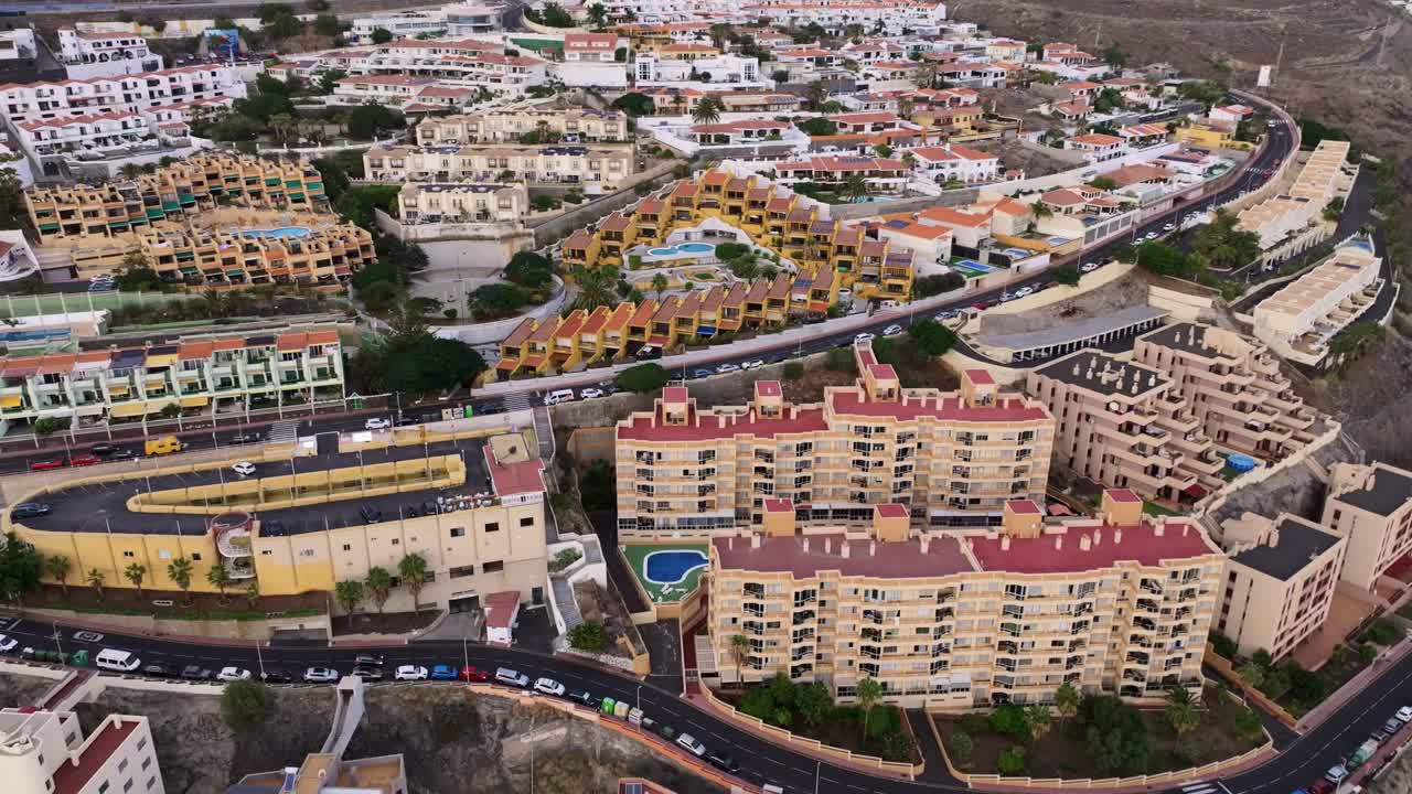 Drone flies downward above Radazul coastal buildings, turns right toward ocean