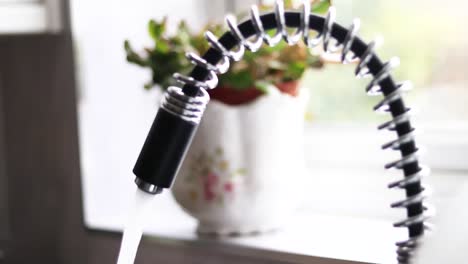 person filling glass by tap water