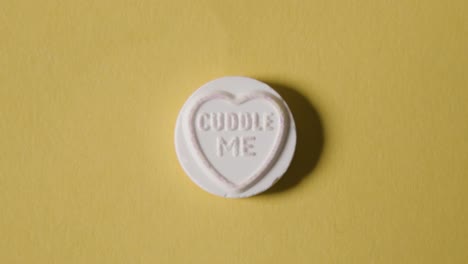 heart candy with cuddle me message on yellow background