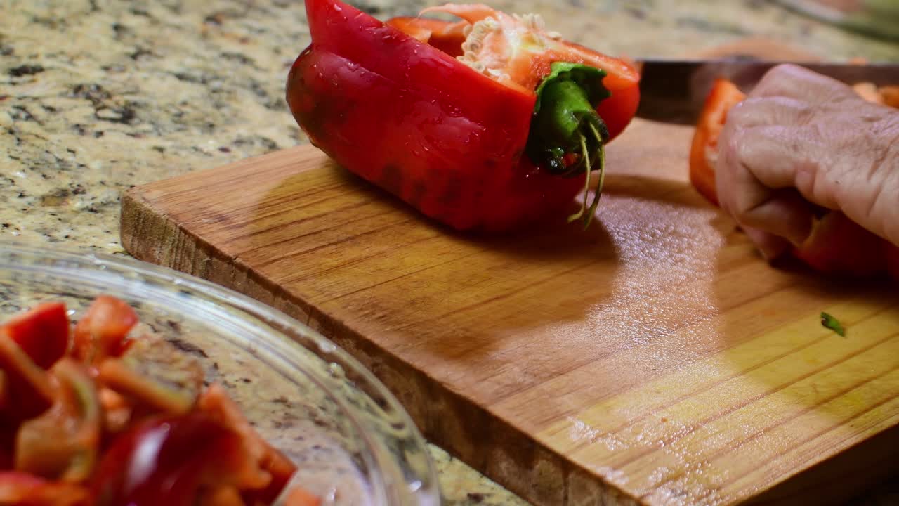 Touching close up grandmother's hands expertly slicing a fresh red bell pepper in a domestic kitchen, symbolizing culinary heritage, traditional recipes, and ancestral wisdom