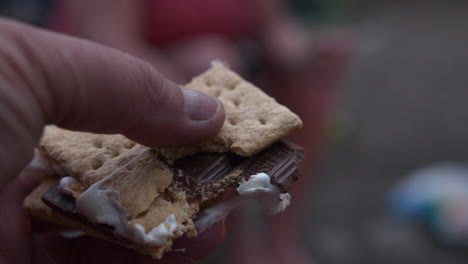 eating a marshmallow and holding it in hand
