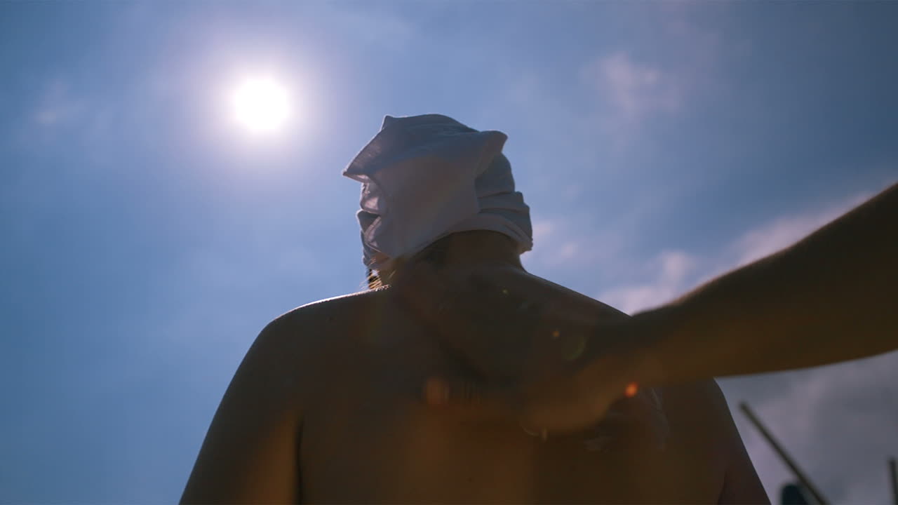 남자가 아내의 등에 자외선 차단제를 고 있습니다.