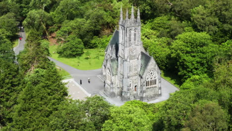 Slow-aerial-dolly-out-shot-of-the-Kylemore-Abbey-during-a-bright-day