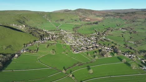 wide aerial point of interest shot focusing on the centre of castleton, locatated in the peak district, uk