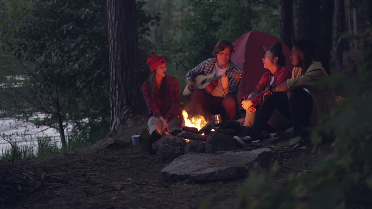 Friends Singing Around a Campfire in the Forest