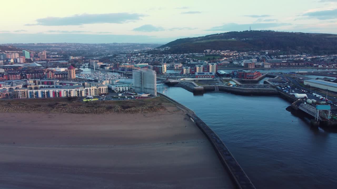 Vista aérea da Praia de Swansea com Entrada para a Marina, com Edifícios Circundantes e Apartamentos de Luxo à Beira-Mar. Segunda Maior Cidade no País de Gales, Reino Unido