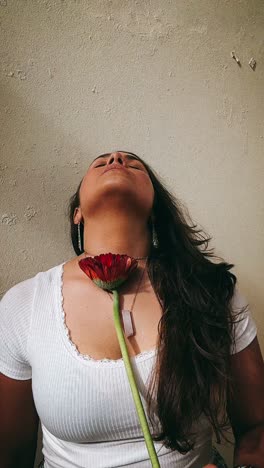 mujer con una flor roja