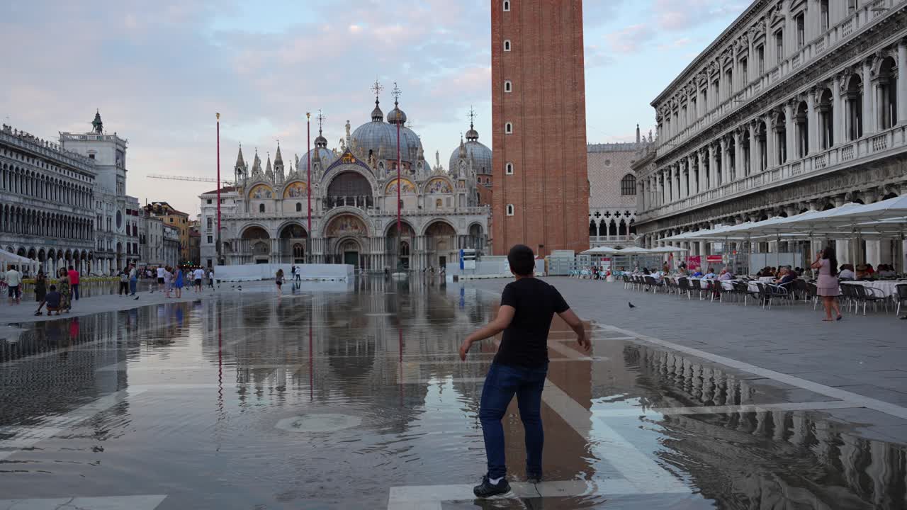 Giovane uomo che schizza nell'acqua a causa dell'alta marea a St.
