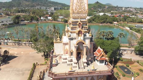 orbit view over top floor terrace of wat chalong pagoda temple in phuket, thailand - aerial slow orbit medium shot