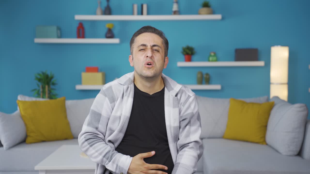 el hombre tiene dolor de estómago.