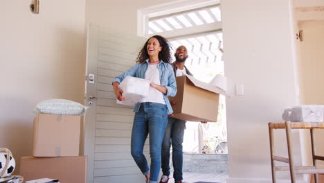 slow motion shot of couple carrying boxes into new home on moving day